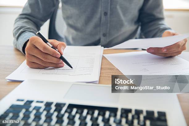 Hombre De Negocios Comprobando Documentos En La Mesa Foto de stock y más banco de imágenes de Documento