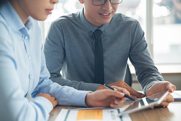 istock Smiling Asian business people discussing data 636172870