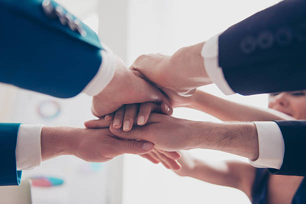 istock team in putting their hands on  top of each other 636173274