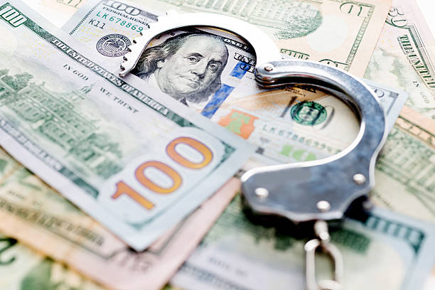 istock Handcuffs lying on american dollars 636173716