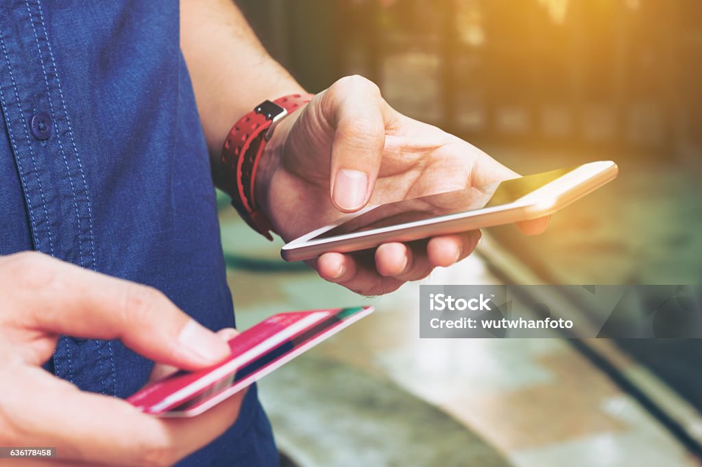 Man use smart phone and holding credit card with shopping Man use smart phone and holding credit card with shopping online. Online payment concept. Mobile Phone Stock Photo