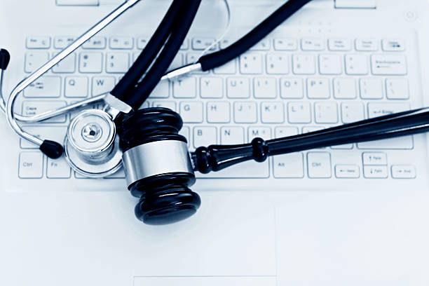 Stethoscope and gavel on keyboard of laptop Stethoscope and gavel on keyboard of laptop. gavel keyboard stock pictures, royalty-free photos & images