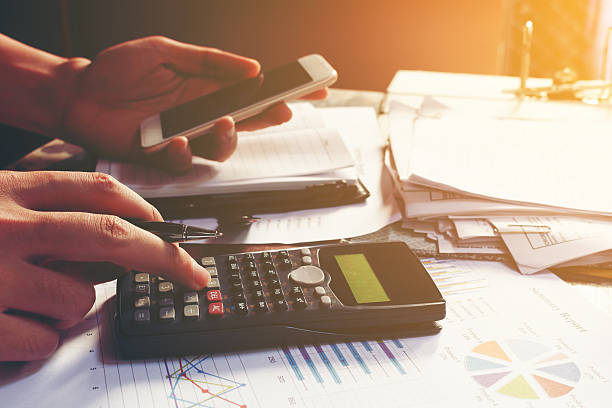 istock Young businessman calculating about cost and using smartphone se 636180078