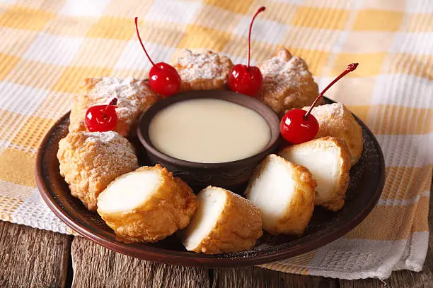 dessert Leche frita and condensed milk, decorated with cherries close-up on a plate. horizontal