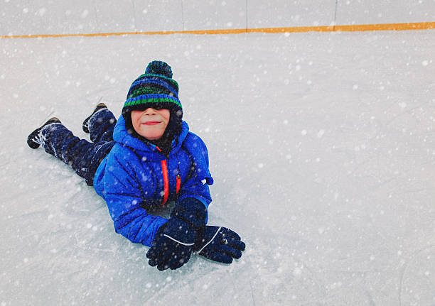 istock cute little boy learning to skate in winter 636187668
