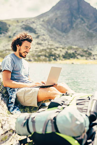 istock Man using a laptop in the mountain 636188278