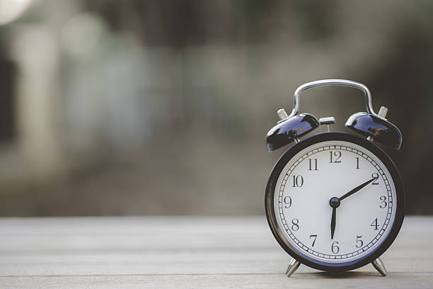 Retro alarm clock on wooden table, vintage style