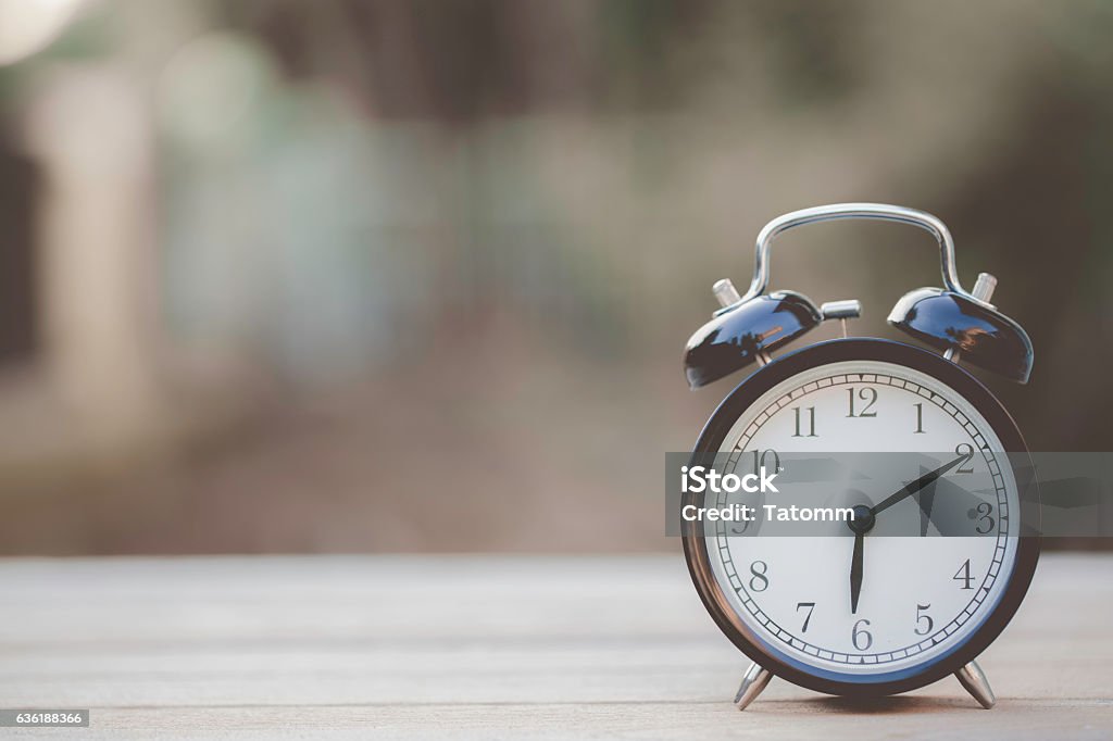 Retro alarm clock on wooden table, vintage style Change Stock Photo