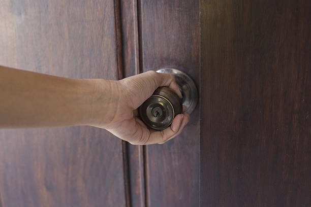 istock hand hold handle of wood door 636188486