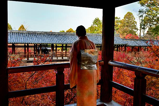 donna giapponese nel kimono che si gode il fogliame autunnale a tofuku-ji, kyoto - obi sash foto e immagini stock