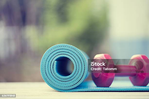 Dumbbell And Yoga Mat On Wood Table Stock Photo - Download Image Now - Exercise Mat, Yoga, Outdoors