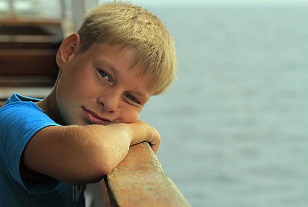 istock boy is sitting on a seat in ferry 636193094