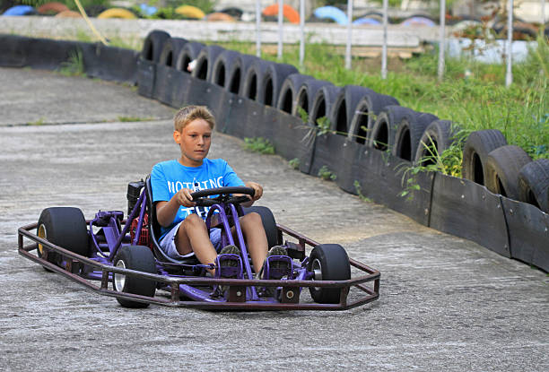 ragazzo sta guidando un kart sul circuito - go carting foto e immagini stock