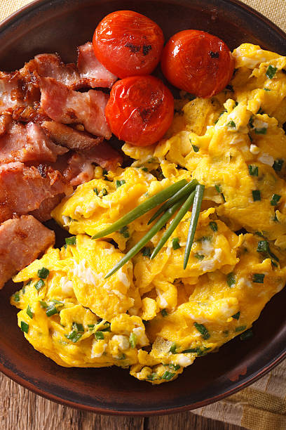 istock scrambled eggs and chives, fried bacon on a plate close-up 636193554