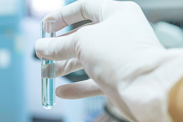 Test tube in scientist hand in laboratory Close-up of glass tube with blue fluid in scientist hand during medical test hipflask stock pictures, royalty-free photos & images