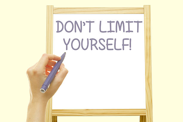 istock Woman hand writing DON'T LIMIT YOURSELF message 636194168
