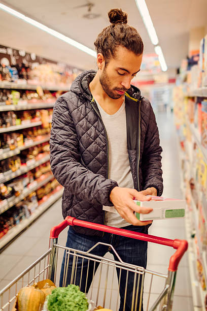 Jeune homme barbu dans un supermarché. - Photo