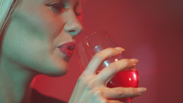 Blonde woman drinking red wine 4K