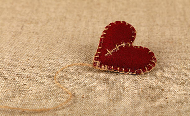 istock Brown felt craft heart over canvas close up 636201682
