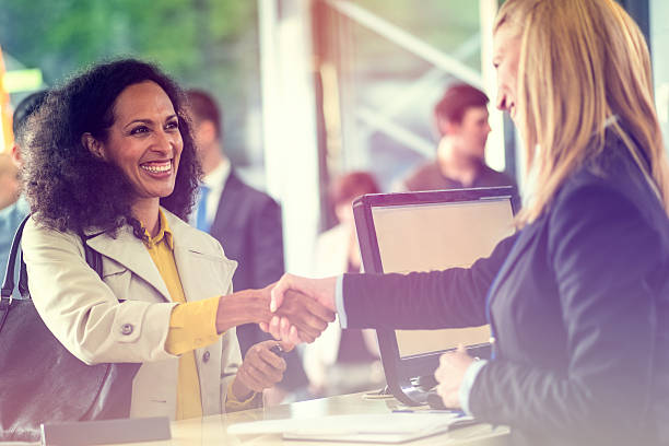 Bank Counter Customer shaking hands with bank teller at bank counter. bank teller stock pictures, royalty-free photos & images