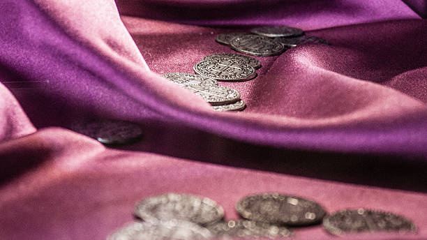 istock Ancient coins on purple satin 636205212