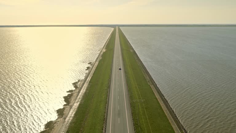 AERIAL Road on a dam in sunshine