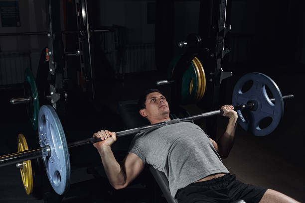 istock man at the bench press lifting a barbell 636207610