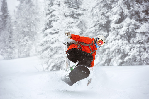 Snowboarder jumps backcountry freeride off-piste ski resort