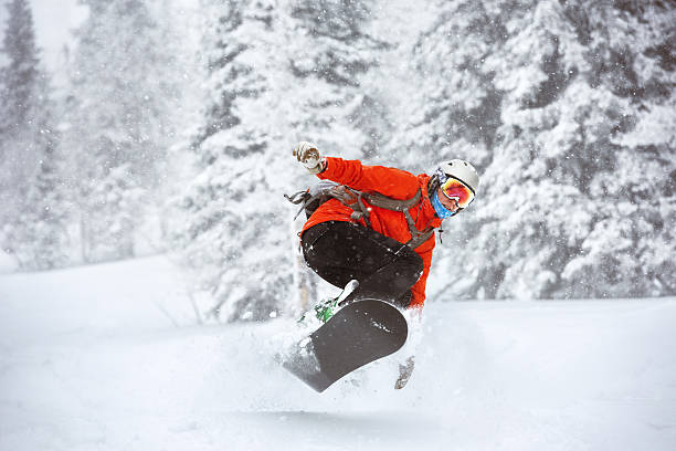 Snowboarder jumps backcountry freeride off-piste ski resort stock photo