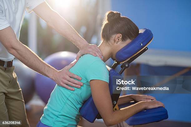 Physiotherapist Giving Back Massage To A Female Patient Stock Photo - Download Image Now