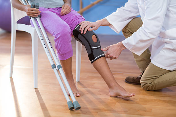istock Physiotherapist examining female patients knee 636208426