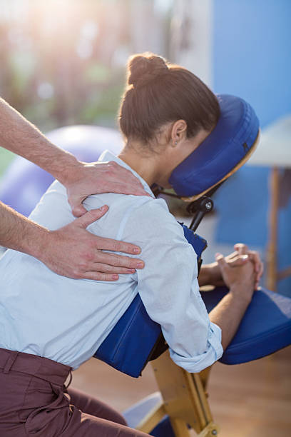 Physiotherapist giving shoulder massage to a female patient stock photo