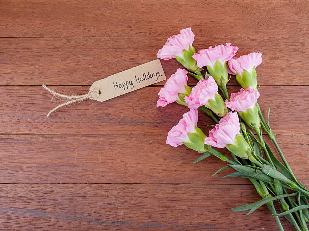 istock Handwriting Happy Holidays and pink carnation flower 1 636208818