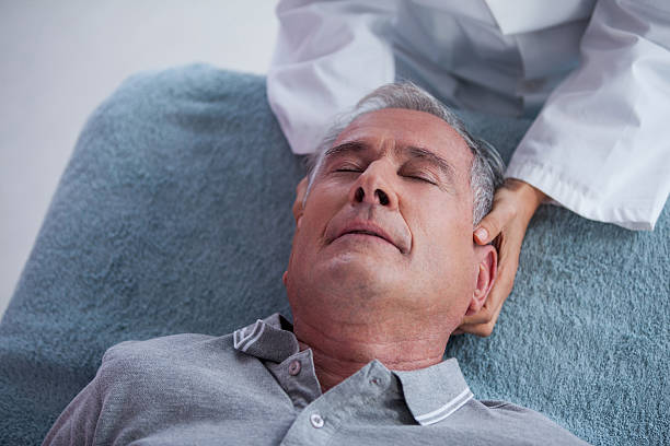 istock Senior man receiving neck massage from physiotherapist 636209346
