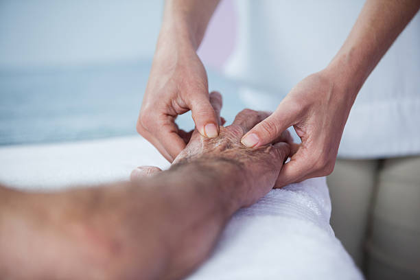 istock Physiotherapist giving hand massage to a patient 636209608