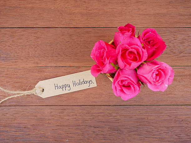 istock Handwriting Happy Holidays and pink rose flower 1 636209676