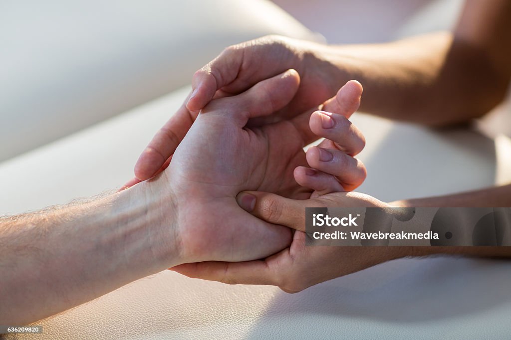 Physiotherapist giving hand massage to patient Close-up of physiotherapist giving hand massage to patient in clinic Hand Massage Stock Photo