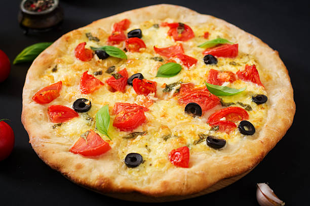 istock Pizza with tomato, mozzarella, basil and olives. 636210110