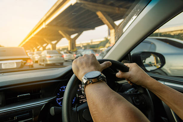 istock Closeup left hand driving on traffic jam background, Business Co 636210224