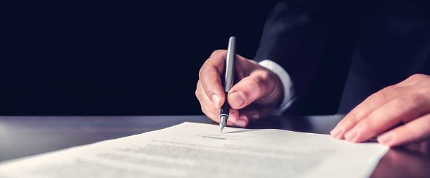 Signing Official Document Businessman Signing An Official Document will legal document stock pictures, royalty-free photos & images