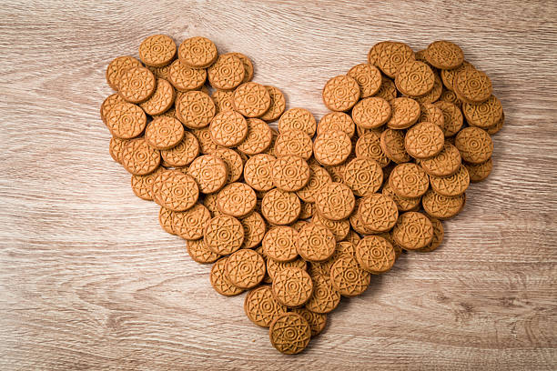 Christmas gingerbread heart form decoration on the wooden table.