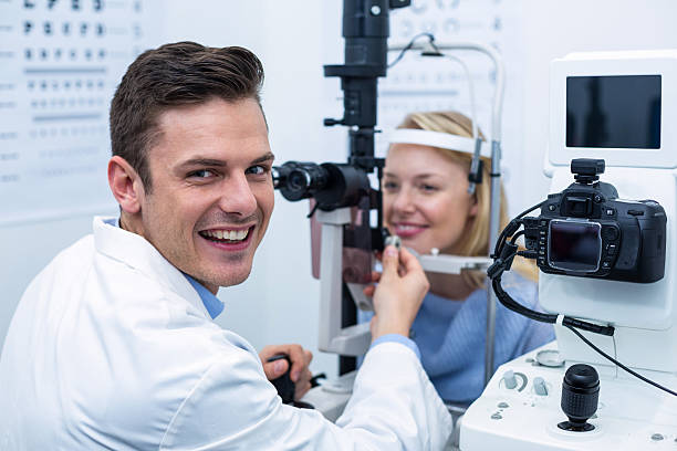 istock Smiling optometrist examining female patient on slit lamp 636214776