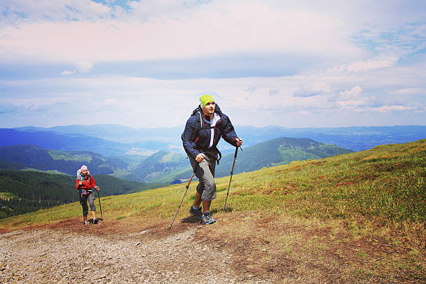 turista uomo che cammina per le montagne con uno zaino. - flores man foto e immagini stock