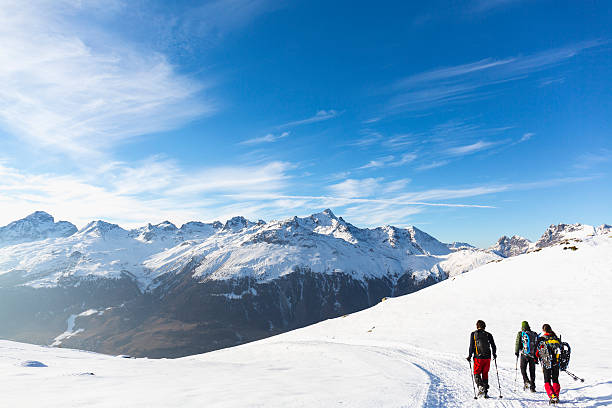 escursionisti che camminano su una strada innevata in alta montagna - st moritz engadine mountain winter foto e immagini stock