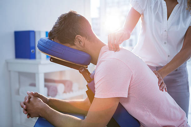 physiothérapeute donnant un massage du dos sur un patient - chaise photos et images de collection