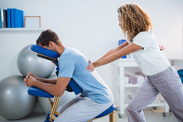 Physiotherapist giving back massage to a patient