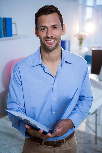 istock Smiling physiotherapist holding clipboard in clinic 636219248