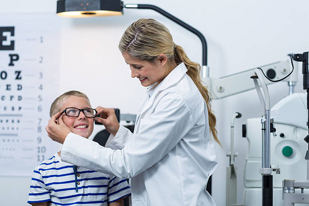 istock Female optometrist prescribing spectacles to young patient 636221374