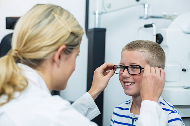 istock Female optometrist prescribing spectacles to young patient 636221382
