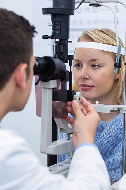 istock Optometrist examining female patient on slit lamp 636221572